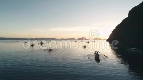 空中无人驾驶飞机观船停泊在海湾与清澈和绿松石水在日落在船上和游艇上视频的预览图