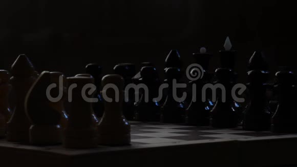 棋盘与棋子在黑暗中黑色背景旋转镜头国际象棋戏剧战视频的预览图