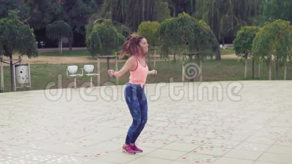 把带着跳绳的漂亮女人放在公园里视频的预览图