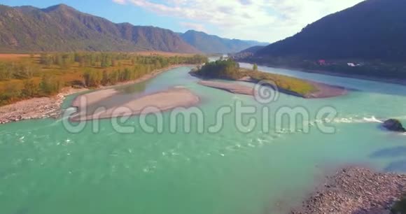 在阳光明媚的夏季早晨低空飞行在带岩石的新鲜快山河上视频的预览图