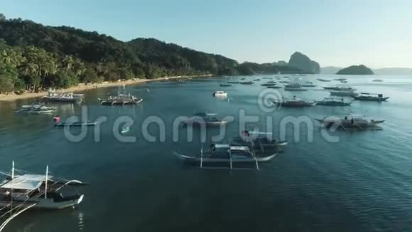 空中无人驾驶飞机观船停泊在海湾与清澈和绿松石水在日落在船上和游艇上视频的预览图