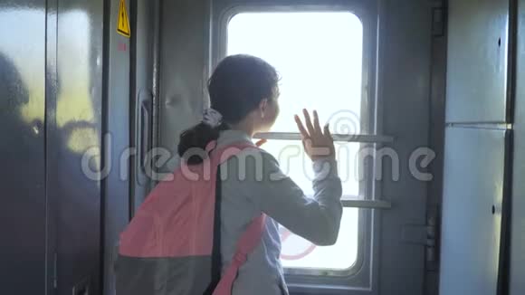 小女孩是一个乘火车旅行的背包客旅游运输铁路概念旅游学校女孩视频的预览图