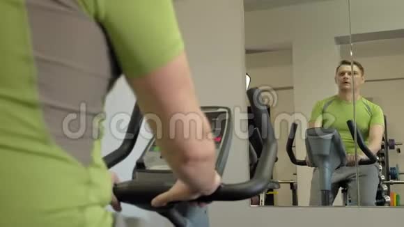 在健身房骑运动自行车的人健康生活方式视频的预览图