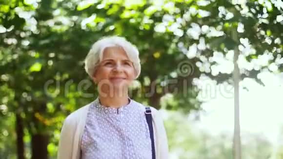 快乐的老人走在夏日公园视频的预览图