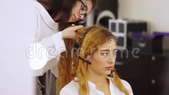 理发师为模特女孩的专业摄影做头发视频的预览图