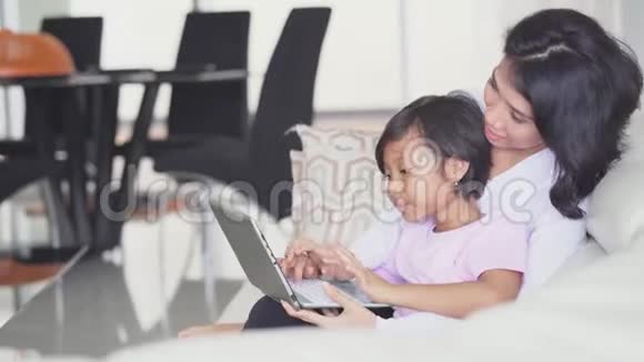 小女孩和妈妈在家玩手提电脑视频的预览图
