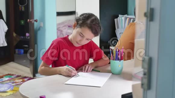 小女孩在桌子上画画女生少年用室内铅笔画画视频的预览图