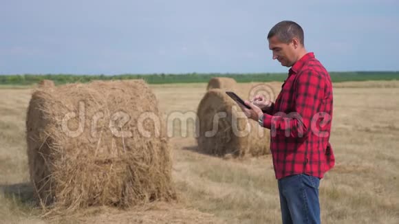 智慧农业理念男子工人农民研究生活方式干草堆在一个领域的数字平板电脑慢慢慢慢视频的预览图