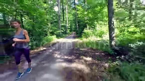 年轻女子在森林里慢跑视频的预览图