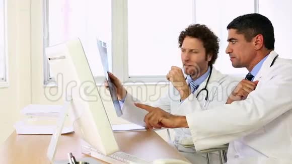坐在办公桌前的医生在谈论X射线视频的预览图