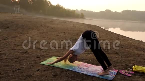年轻漂亮的女人在海滩上做瑜伽视频的预览图