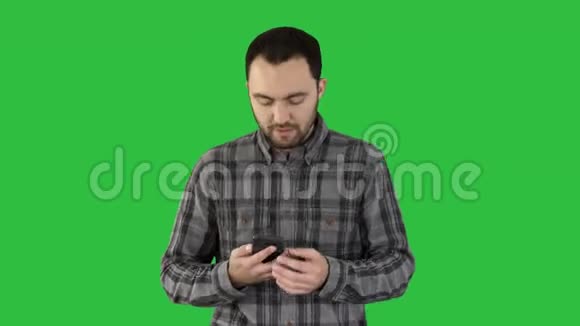 一个男人正在打电话在绿色屏幕上微笑Chroma键视频的预览图