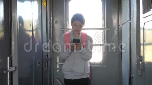 带背包的年轻女孩旅行者站在生活方式旁边车窗上放着一部智能手机旅费视频的预览图
