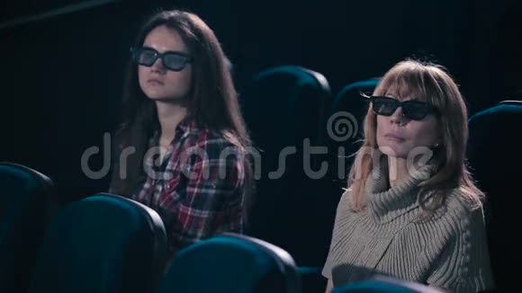 两个女人在电影院里微笑视频的预览图