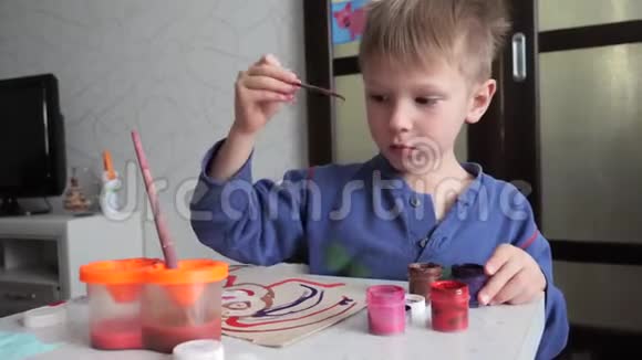小男孩热情地在纸上用水彩作画视频的预览图
