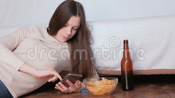 悲伤的年轻美丽的黑发女人在手机上打字视频的预览图