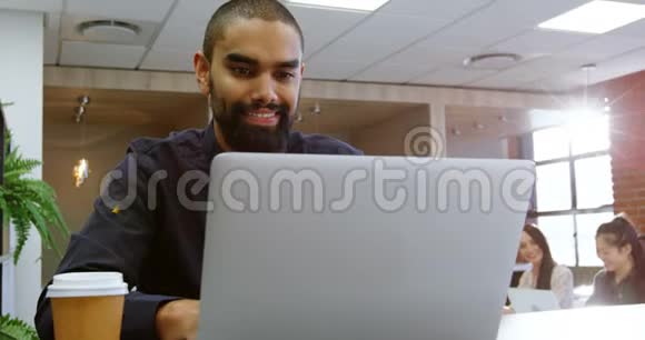 办公室自助餐厅使用笔记本电脑的男性高管视频的预览图