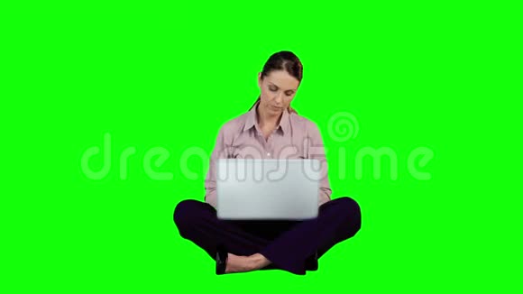 女商人在绿色屏幕上使用笔记本电脑视频的预览图