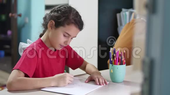 小女孩在桌子上画画女学生青少年在室内用铅笔画画视频的预览图