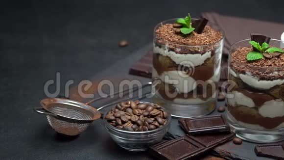 经典的提拉米苏甜点在一杯和一杯咖啡在黑暗的混凝土背景视频的预览图
