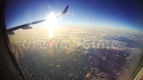 从太阳背景云层上方的飞机窗口观看视频的预览图