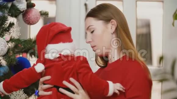 妈妈带着孩子在圣诞树旁视频的预览图