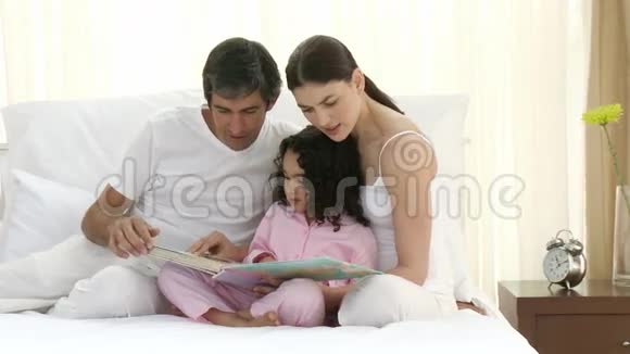 父母和女儿在床上看书视频的预览图