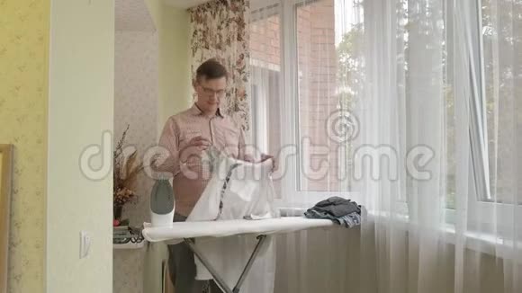 一个男人在他家的熨衣板上抚摸他的衬衫视频的预览图