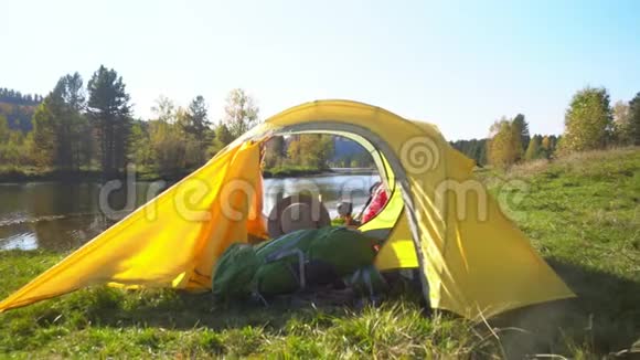 露营妇女躺在帐篷里穿着徒步旅行靴在度假时放松视频的预览图