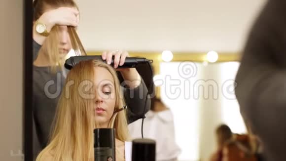理发师为模特女孩的专业摄影做头发视频的预览图