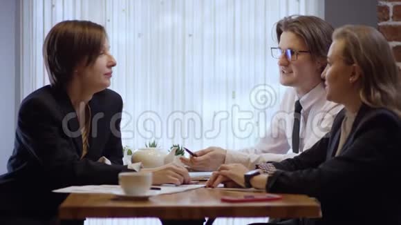 三个人一起工作在一家咖啡馆里讨论一份合同女人和男人在餐馆或咖啡里视频的预览图