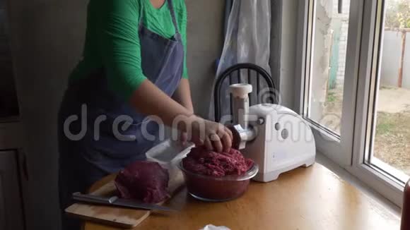围着围裙的女厨师正在厨房里准备一个装满肉的甜椒女孩在辣椒里放上碎肉视频的预览图