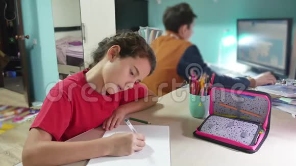 小女孩在桌子上画画女学生少年用铅笔在室内画画视频的预览图