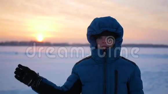 日落时在冬季公园里挥手致意的孩子视频的预览图