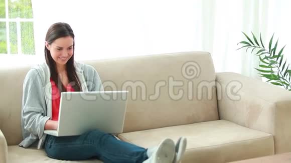 微笑的黑发女人用她的个人电脑视频的预览图