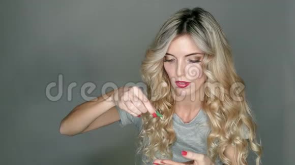 一只透明的隐形眼镜在一个美丽的金发女郎手中她正准备插入它视频的预览图