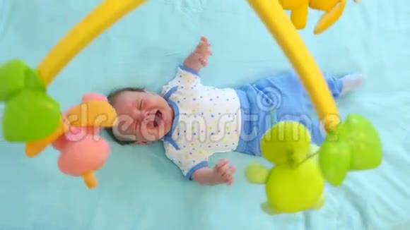 小可爱的小男孩躺在婴儿床上带玩具视频的预览图