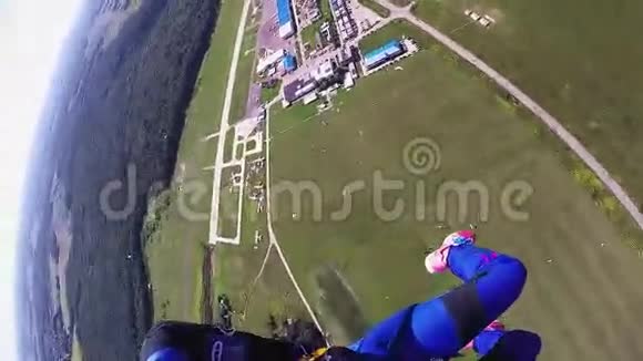 专业跳伞运动员在绿色的场地上跳伞景观夏季视频的预览图
