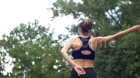 在公园的运动场上从事健身运动的年轻运动员女子视频的预览图