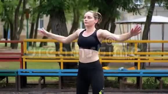 在公园的运动场上从事健身运动的年轻运动员女子视频的预览图