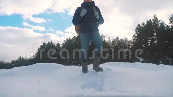 人的脚在深雪的冬天生活方式慢动作视频背着背包的人在雪地森林里散步视频的预览图