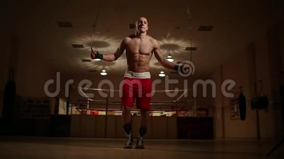 一个穿着拳击鞋和短裤的男人在体育馆里打拳击视频的预览图
