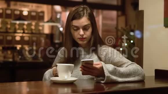 美丽的女孩与电话在咖啡厅视频的预览图