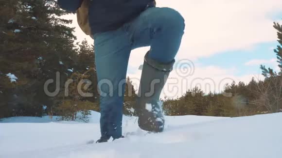 人的脚在深雪的冬天慢动作视频一个背包旅行的人在雪地森林里散步冬天视频的预览图