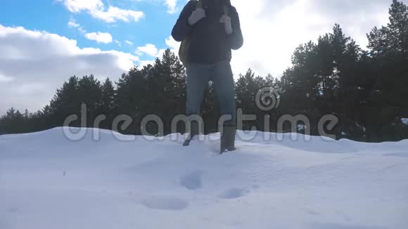 人的脚在深雪的冬天慢动作视频带着生活方式背包的人在雪地森林里散步视频的预览图