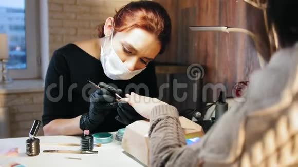 戴着医用口罩的女修甲师在美容院修指甲视频的预览图