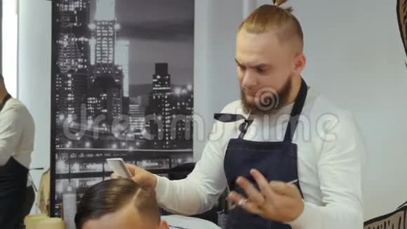 男士美容师理发店理发师为一个年轻人做发型一个理发师带着视频的预览图