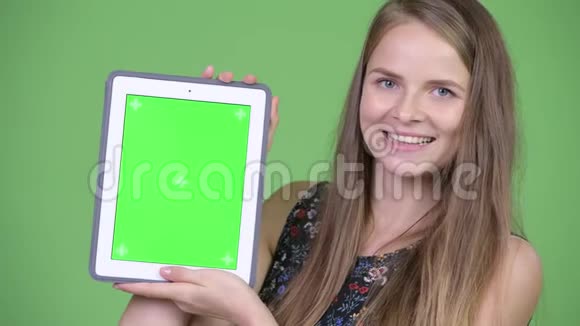 年轻快乐的美女展示数码平板电脑视频的预览图