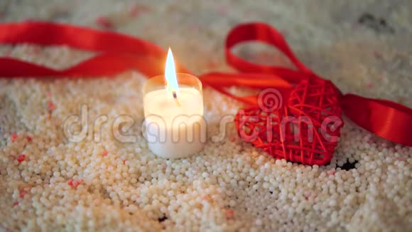 在沙滩上用蜡烛和丝带装饰情人节视频的预览图