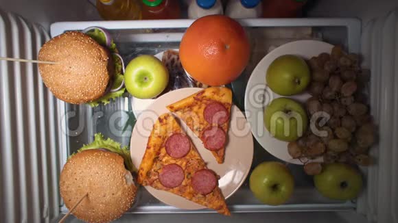 平躺的手在晚上拿食物放在冰箱的架子上视频的预览图